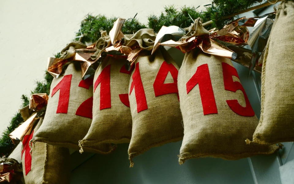 The plumply filled, numbered bags of an advent ccalendar are hung in a row.