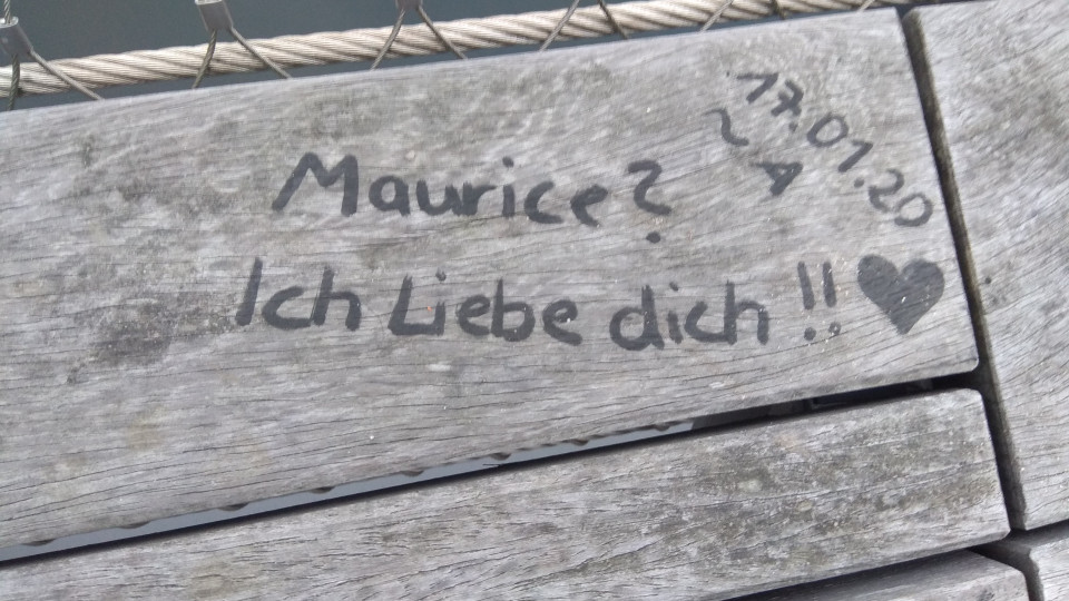 a message on a wooden bench saying 'Maurice? I love you!!' with a heart next to it
