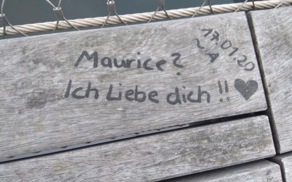 a message on a wooden bench saying 'Maurice? I love you!!' with a heart next to it