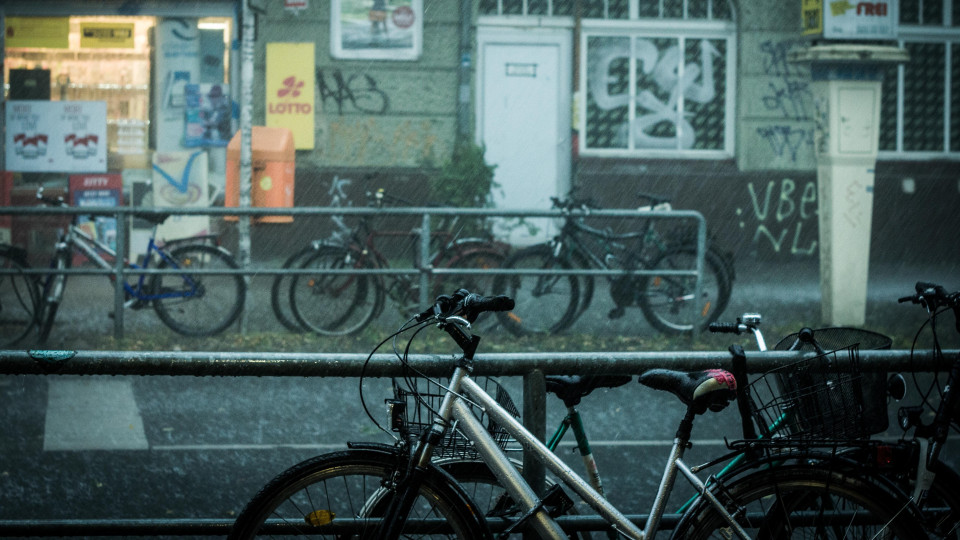 A street in Berlin with bicycles leaning on railings on both sides.
