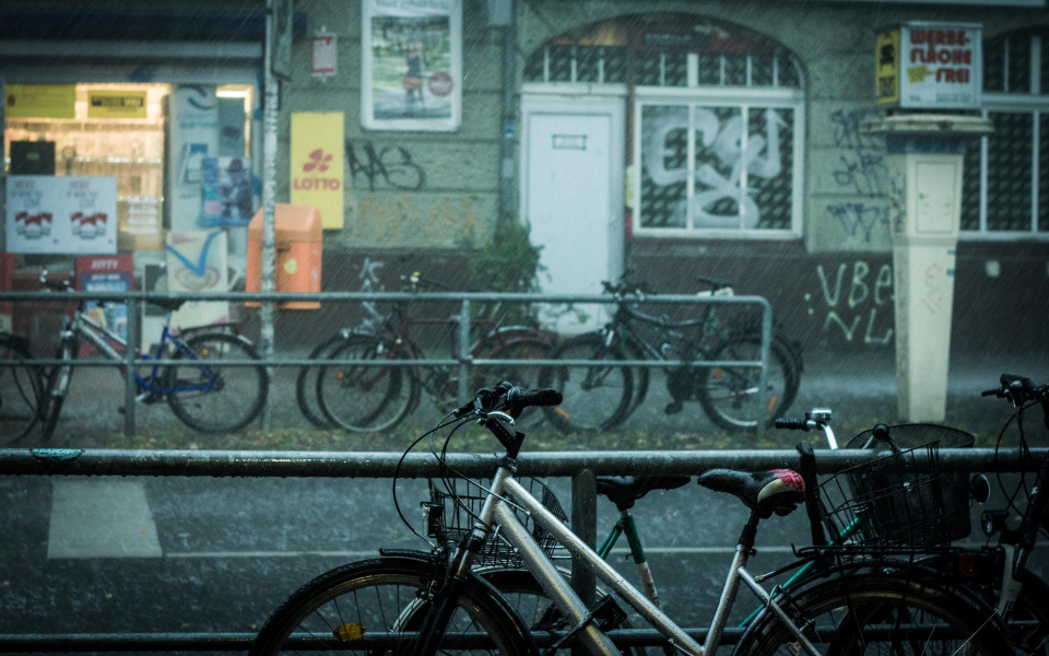 A street in Berlin with bicycles leaning on railings on both sides.