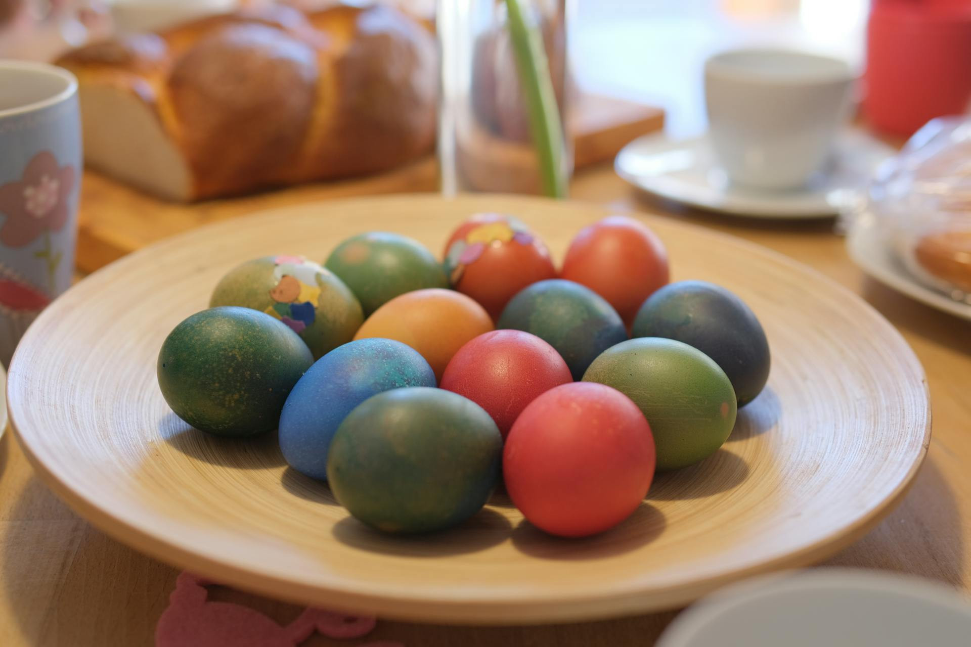 Colored Easter eggs on a wooden plate.