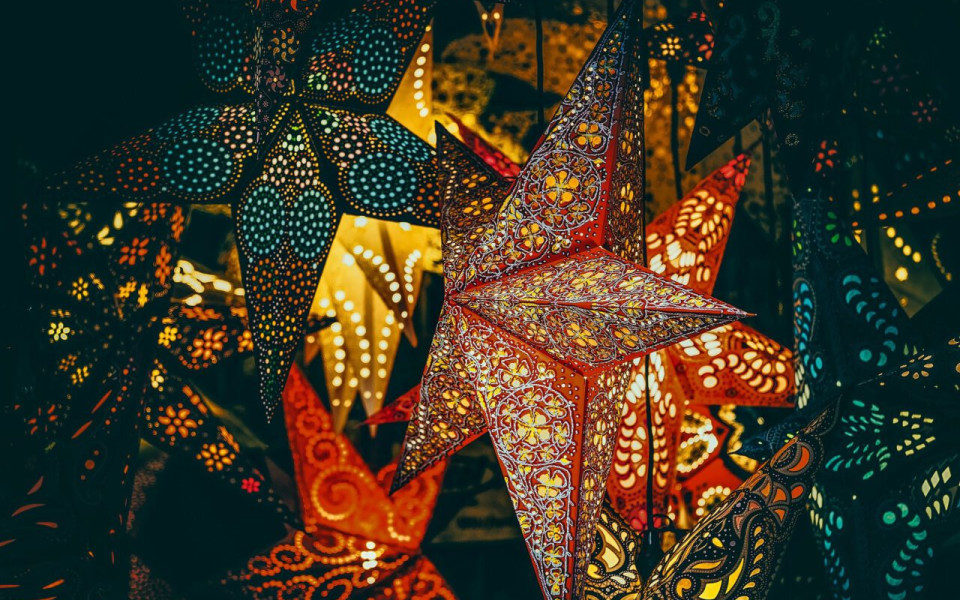 Decorative star-shaped Christmas ornaments shine in the darkness.