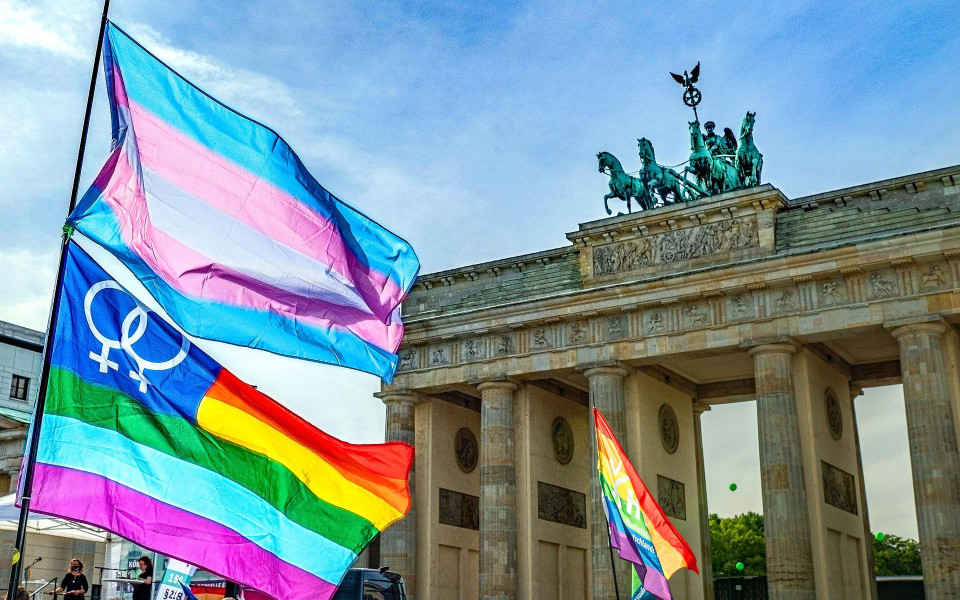 Lesbian Pride and Trans Pride flags fly in front of the Brandenburg Gate.